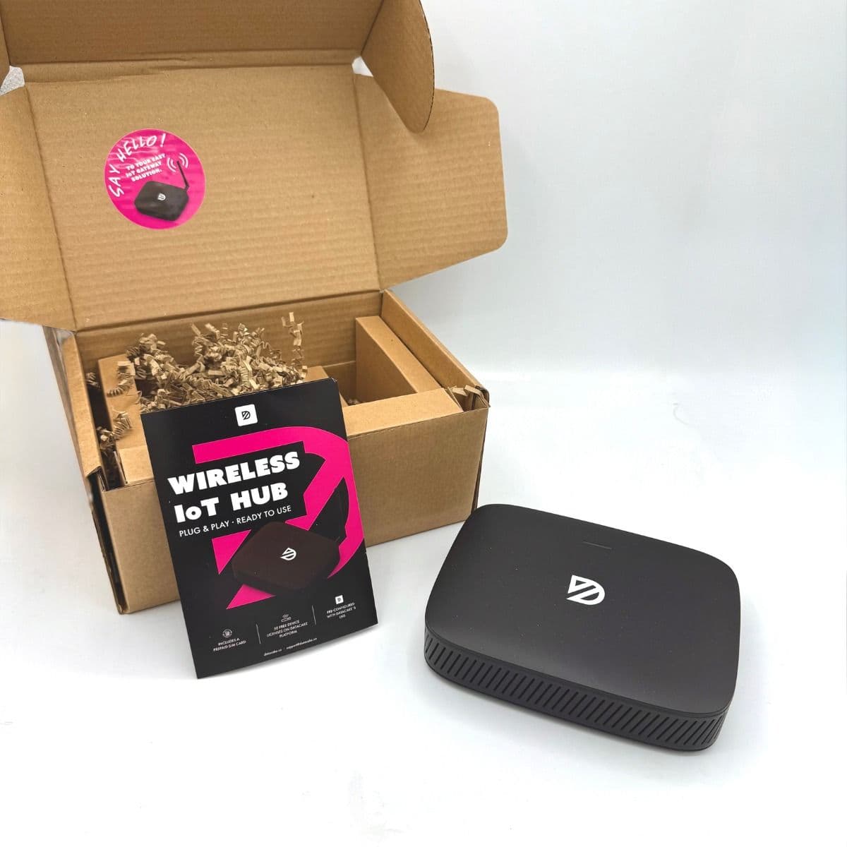 Datacake Wireless IoT Hub unboxed next to its packaging and quick start flyer with pre-installed SIM card